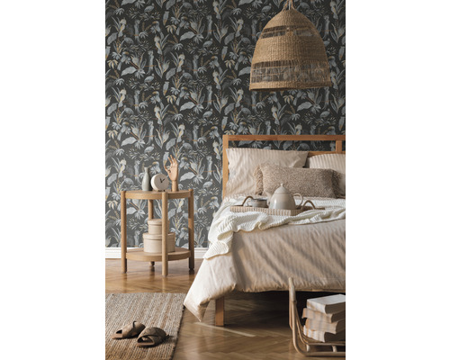 Chambre avec lit devant un papier peint à motifs jungle avec plantes et oiseaux
