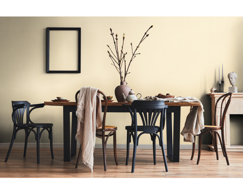 Salle à manger avec table en bois, chaises et décorations dans une pièce lumineuse.