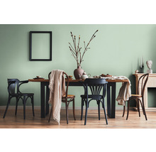 Salle à manger avec table en bois, chaises et décorations dans une pièce lumineuse.