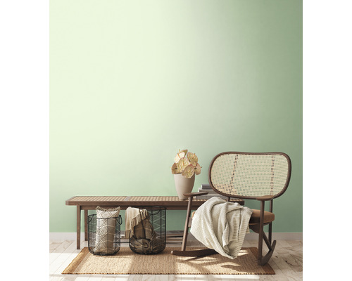 Intérieur clair et accueillant avec banquette, fauteuil en rotin, paniers et décoration sur un tapis.