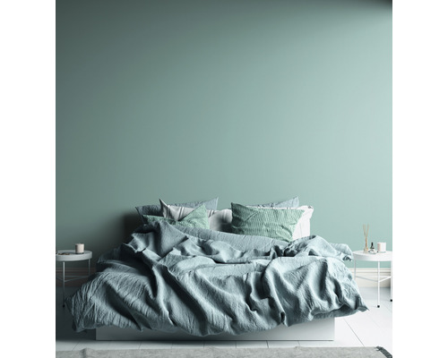 Chambre avec lit, coussins et tables de chevet.