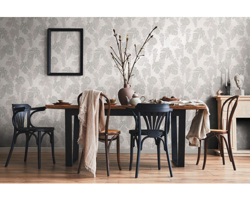 Salle à manger avec table, chaises et papier peint orné de feuilles