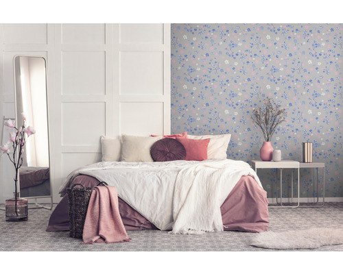 Chambre avec lit, miroir et papier peint floral pour une ambiance cosy.