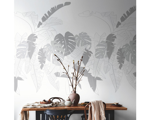 Salle à manger avec table à manger et papier peint mural à motifs de feuilles