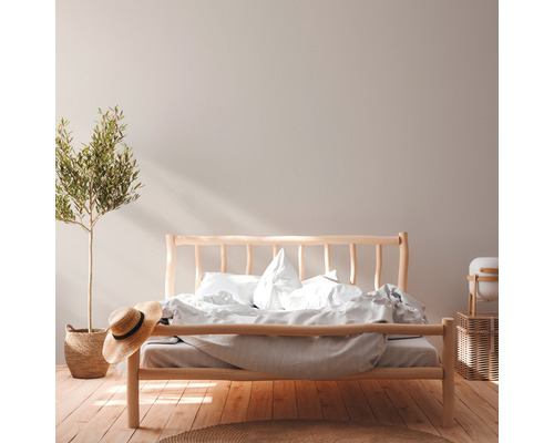 Chambre avec lit en bois, plante d''intérieur et chapeau de paille