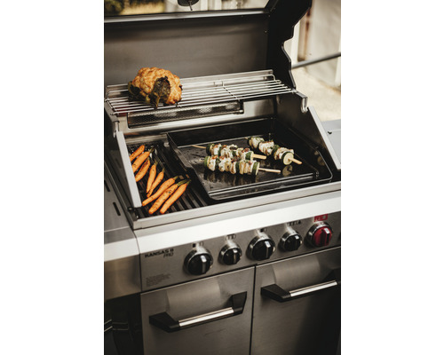 Barbecue en acier inoxydable avec carottes préparées, brochettes de légumes et rôti