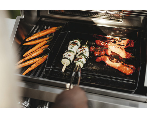 Des légumes comme des carottes, des brochettes de courgettes et des poivrons sur un gril.