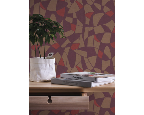 Ambiance de vie décorative avec papier peint à motifs, plante et livres sur une table.