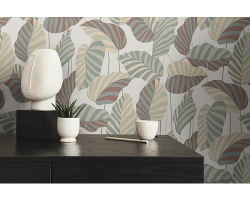 Dekoratives Zimmer mit Blättermuster-Tapete, Gesichtsskulptur und Schreibtisch