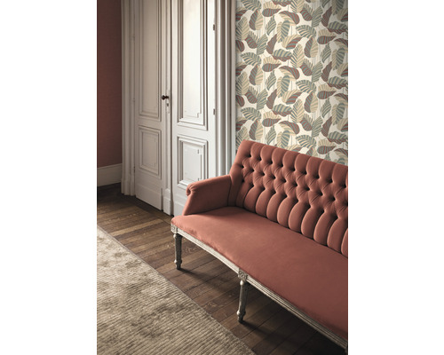 Raumansicht mit gemusterter Tapete, einem Sofa und einer Tür