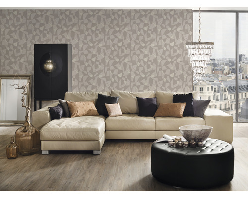 Wohnzimmer mit Sofa, Hocker, Schrank und geometrischer Tapete