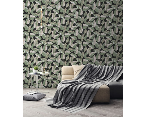 Salon avec canapé et papier peint à motif de feuilles.