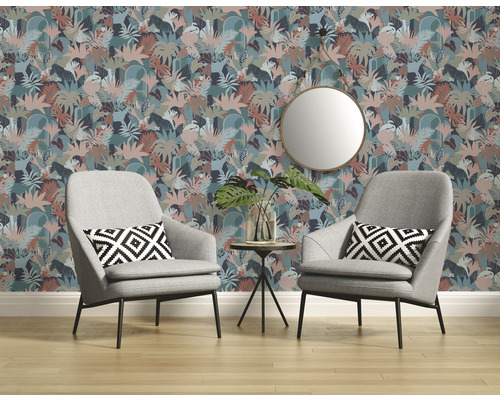 Salon avec papier peint à fleurs, deux fauteuils gris et un miroir rond