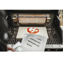 Gril avec pierre à pizza et pizza avec sauce tomate et fromage