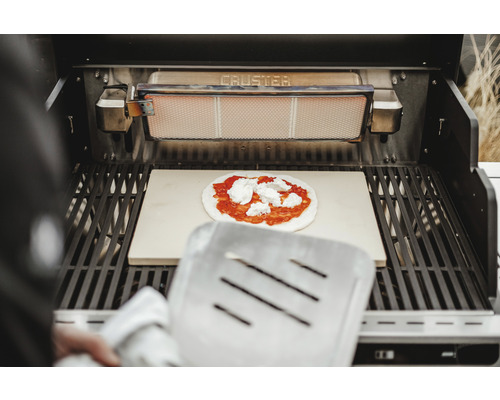 Gril avec pierre à pizza et pizza avec sauce tomate et fromage