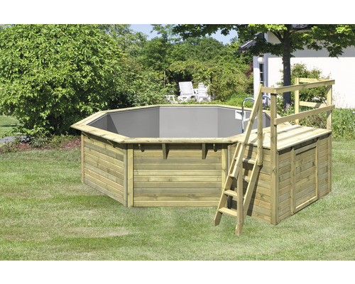 Piscine octogonale en bois avec échelle et plateforme dans le jardin.