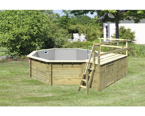 Piscine octogonale en bois avec échelle et plateforme dans le jardin.