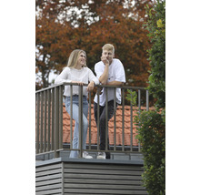 Un homme et une femme se tiennent sur un balcon avec une balustrade en métal
