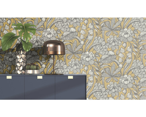 Scène décorative avec papier peint floral, commode, lampe, vase et cactus