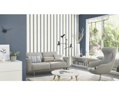 Salon avec canapé, fauteuil et papier peint rayé pour un aménagement intérieur élégant