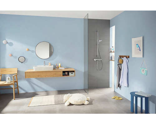 Salle de bain lumineuse avec lavabo, miroir et douche