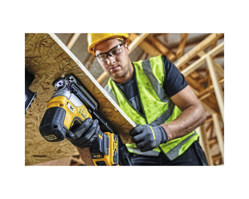 Artisan fixant une plaque de bois avec un cloueur à batterie DeWalt