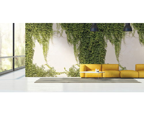 Helles Wohnzimmer mit Fensterfront, begrünter Wand und gelbem Sofa