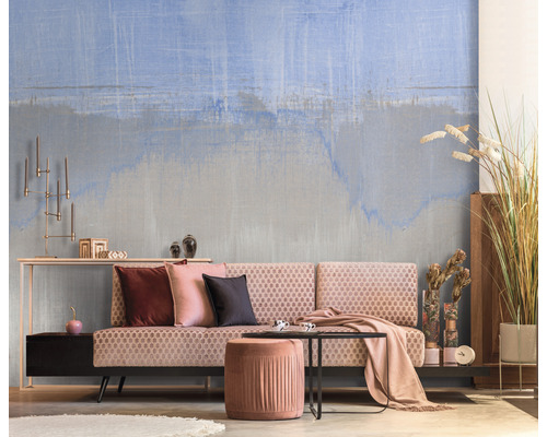 Salon avec papier peint à motifs, canapé, tabouret et décoration