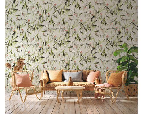 Salon avec papier peint à motifs, canapé et fauteuils en rotin