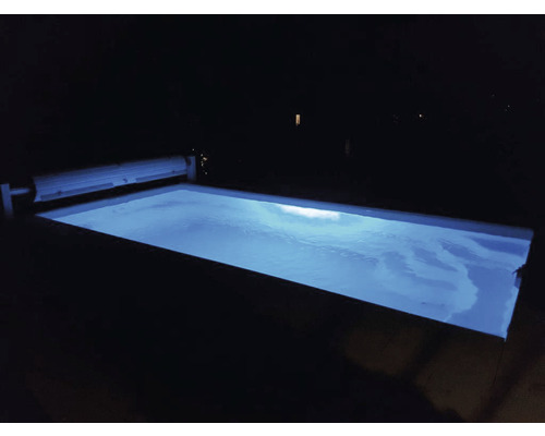 Beleuchteter Swimmingpool bei Nacht mit Poolabdeckung