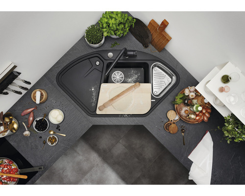 Eckspüle mit Armatur und diversen Küchenutensilien auf einer Küchentheke.