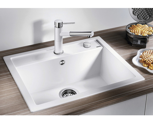 Spülbecken mit Armatur und Ablauffernbedienung auf einer Küchentheke.