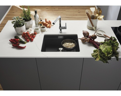 Évier de cuisine avec robinetterie et divers aliments sur le plan de travail