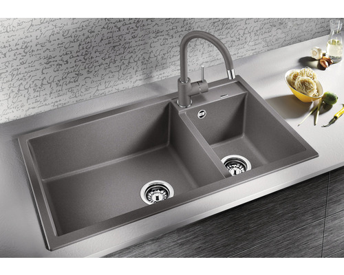 Doppelspüle aus Granit mit Wasserhahn auf einer Küchentheke.