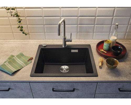 Küchenszene mit schwarzem Spülbecken, Armatur und Geschirr