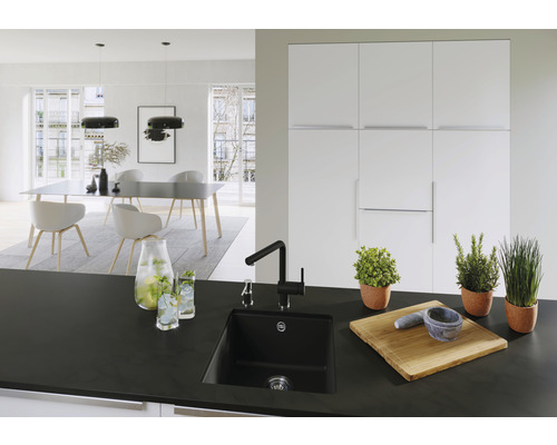 Moderne Küche mit schwarzer Spüle, Armatur und Holzzubehör auf der Arbeitsplatte.