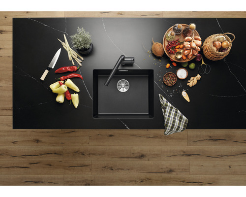 Évier de cuisine avec robinet sur un comptoir de cuisine avec des aliments.