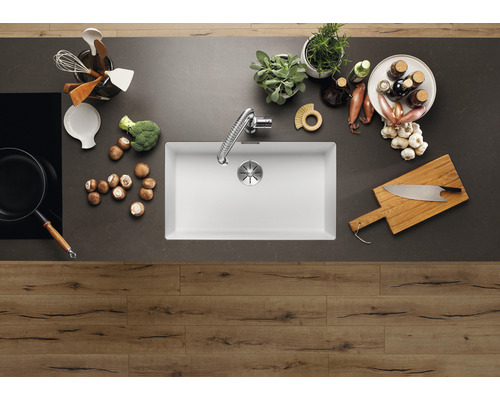 Scène de cuisine avec évier, robinet, plaque de cuisson et ustensiles de cuisine sur un plan de travail