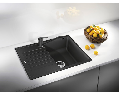 Évier avec égouttoir et robinet sur un plan de travail de cuisine.