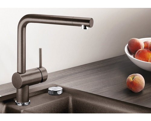 Robinet de cuisine sur un évier avec un bol de fruits et une pêche