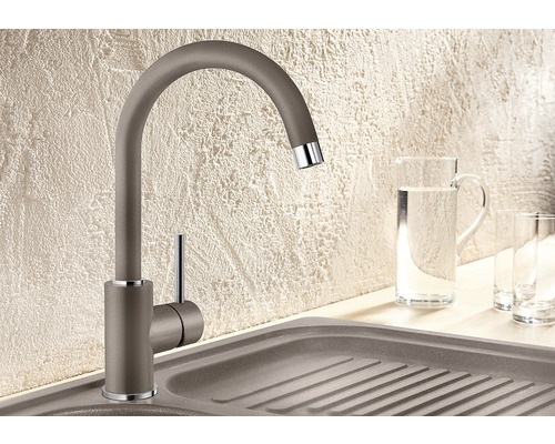 Robinet de cuisine en métal avec col de cygne à côté d''un évier et de verres