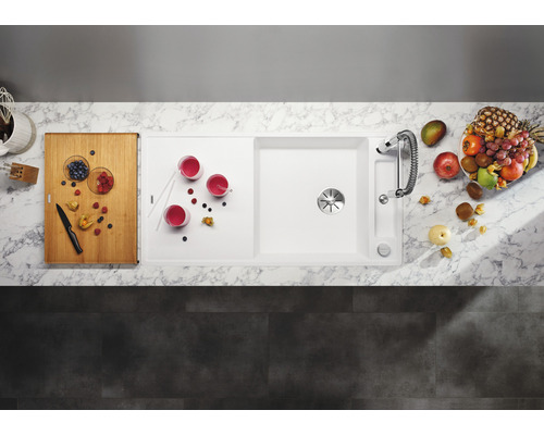 Scène de cuisine avec évier, robinet, planche à découper, verres et fruits vus du dessus