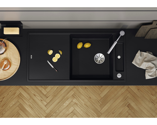 Schwarzes Spülbecken mit Abtropffläche, Armatur und Zitrone