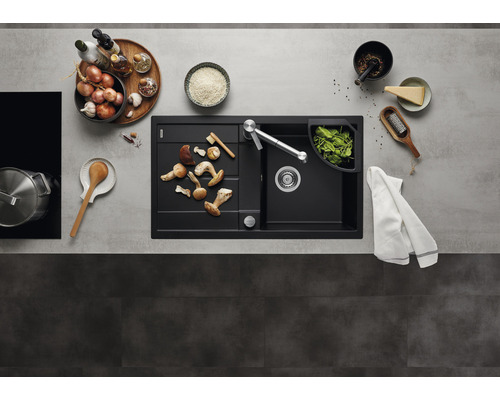 Évier de cuisine avec égouttoir, robinet et aliments sur un plan de travail.