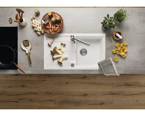 Scène de cuisine avec évier, robinet, ustensiles de cuisine et aliments sur un plan de travail.