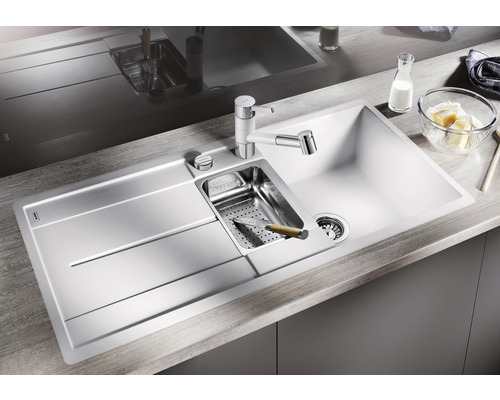 Spüle mit Abtropffläche, Armatur, Sieb und Spülmittelspender auf einer Küchentheke