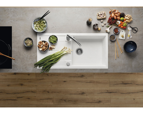 Scène de cuisine avec évier, robinetterie et divers aliments pour la préparation des repas