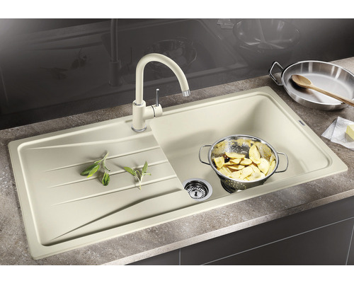 Spüle mit Abtropffläche, Küchenarmatur und Speiseresten im Sieb