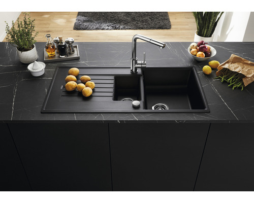 Spüle mit Abtropffläche auf einer Küchenarbeitsplatte mit Lebensmitteln