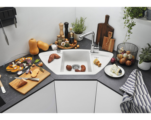 Eckspüle mit Armatur und verschiedenen Lebensmitteln in einer Küche